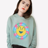 Graphic sweatshirt cropped in green with a cartoon smiley face.