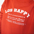 Close-up photograph of the slogan reading: Los Happy, Self-Carefornia, Team Wellbeing.